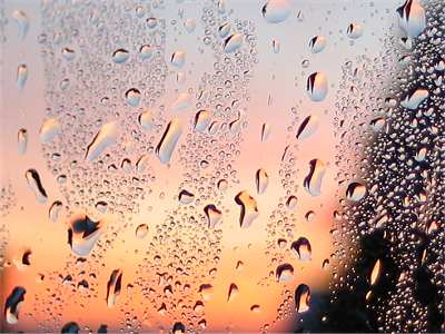 Regentropfen auf Glas vor einem Sonnenaufgang