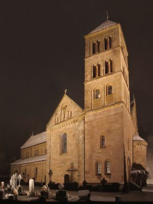 verschneiter Friedhof und Kirche bei Nacht